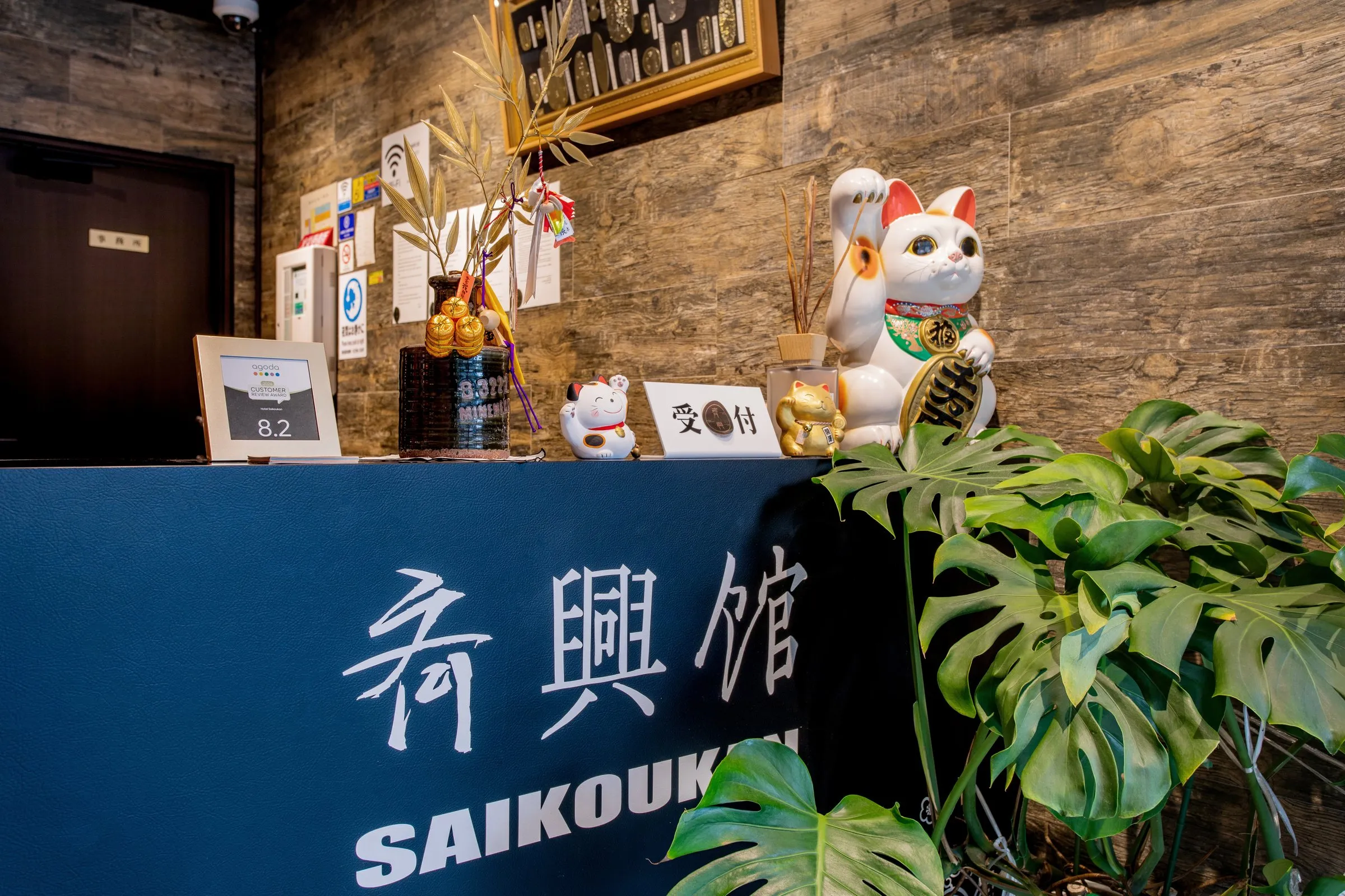 斉興館の看板と招き猫のあるフロント