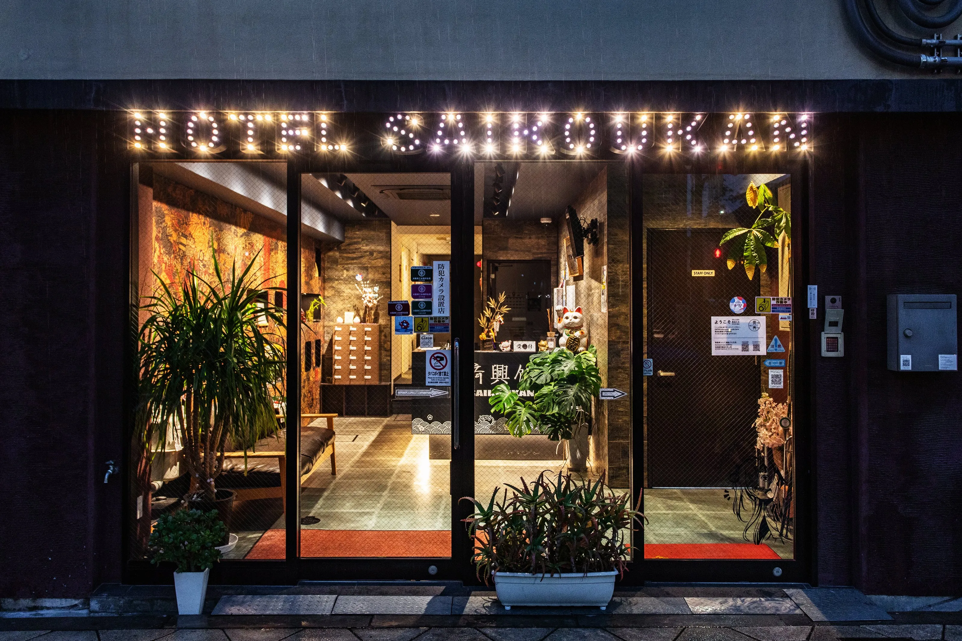 夕暮れの斉興館の入口。HOTEL SAIKOUKAN の看板