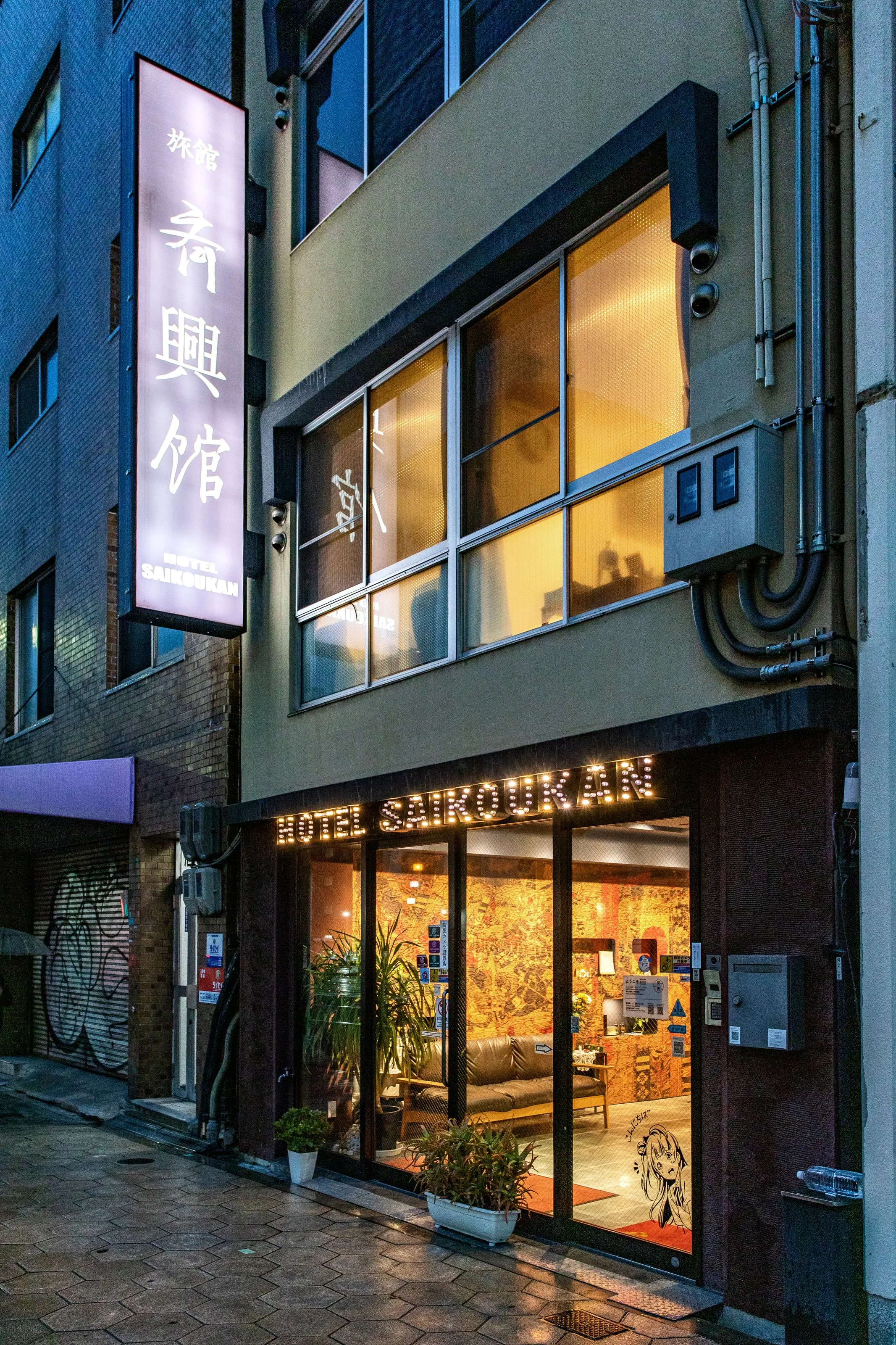 夕暮れの宿。縦の看板と入口の電飾