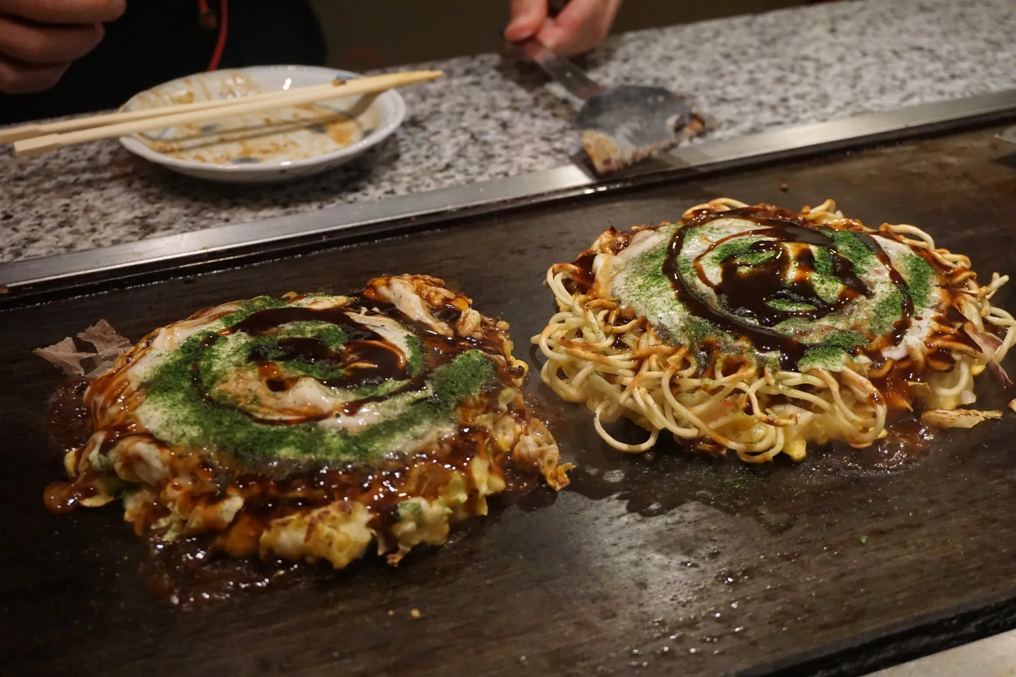 Okonomiyaki cooking on a teppan griddle